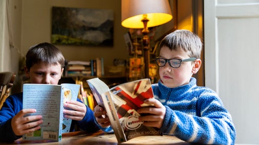 Children reading in the second hand bookshop at Allan Bank and Grasmere, Cumbria.
